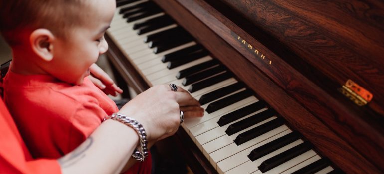 Woman and a child playing a piano while waiting for piano movers MD