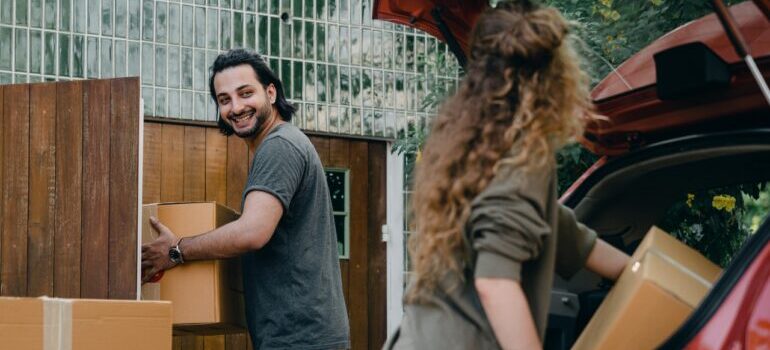 A woman and a man packing things into a car before hiring the best residential movers Washington DC has.