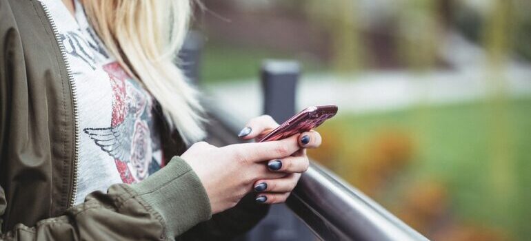 A woman holding a phone, getting ready to call interstate movers Washington DC.