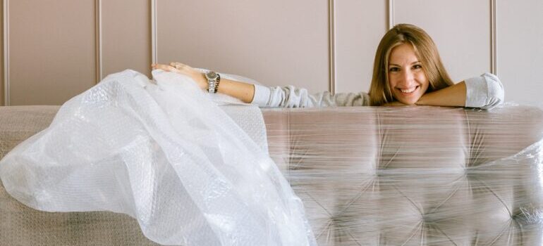 Woman smiling behind a packed sofa