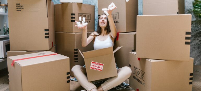 Woman sitting and packing boxes.