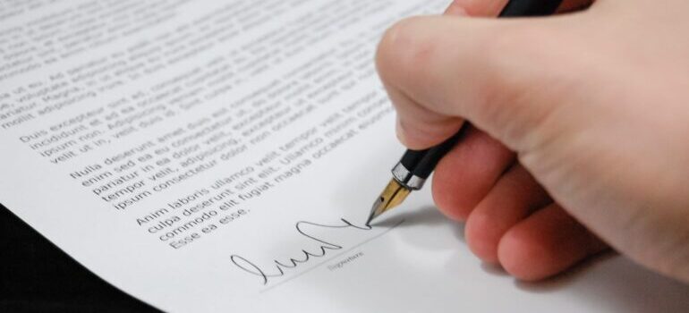 Person holding pen and signing the contract 