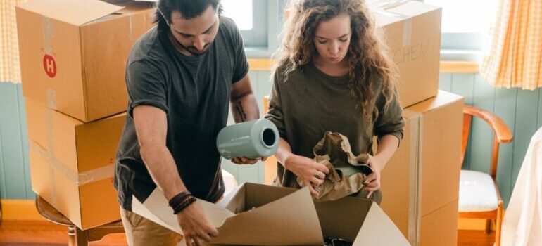 man and woman packing items in a box