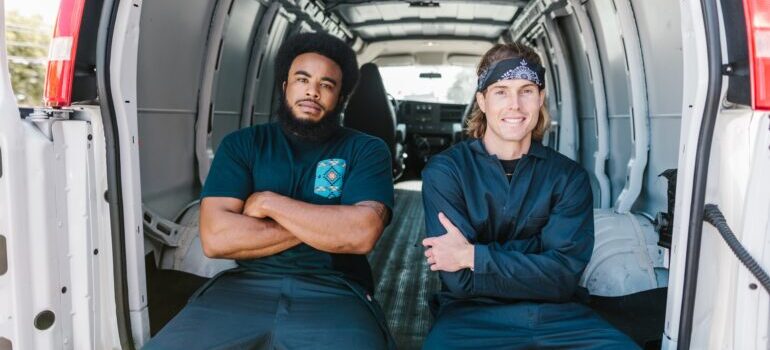 Men sitting in the back of a van.