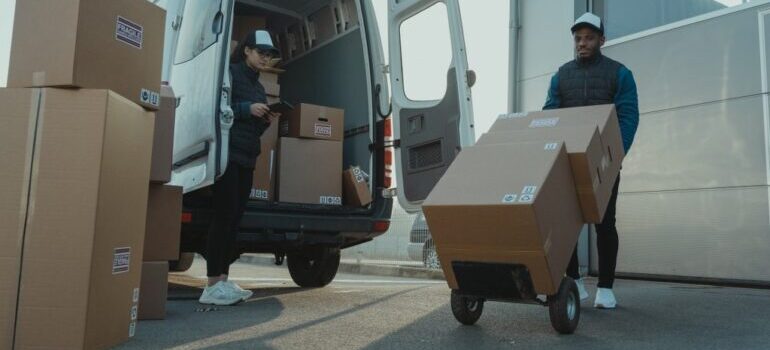 man using a hand truck to move boxes