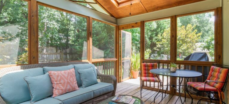 a living room with wooden floors and walls with an exit to the backyard