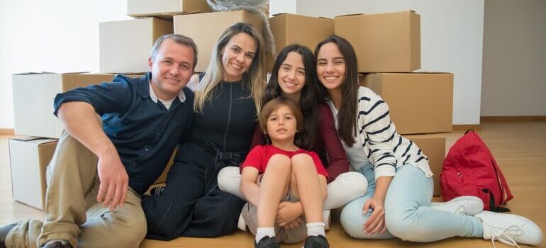 Family sitting in front of the moving boxes