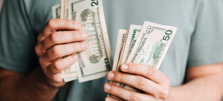 a man counting money in front of another person