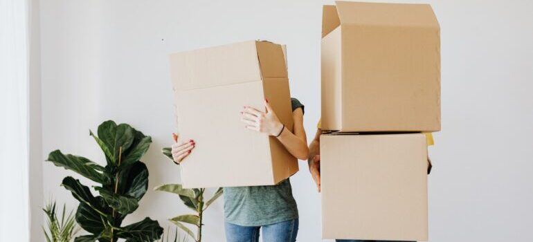 A couple holding boxes.