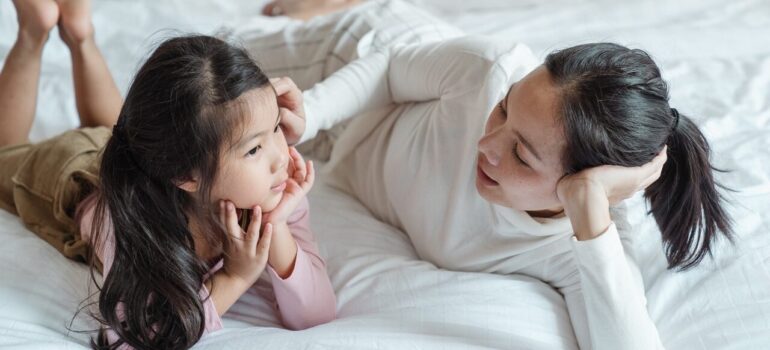 a mother talking to her daughter on the bed