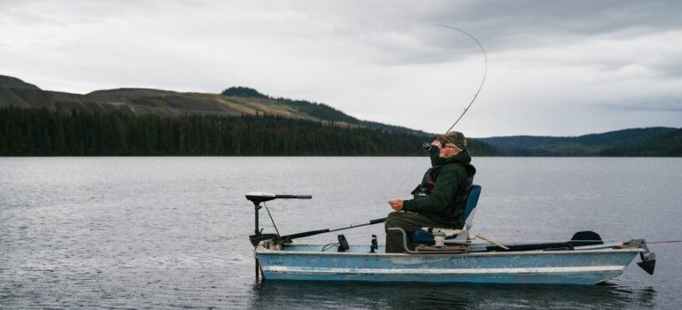 a person sitting in a boat in a lake while fishing