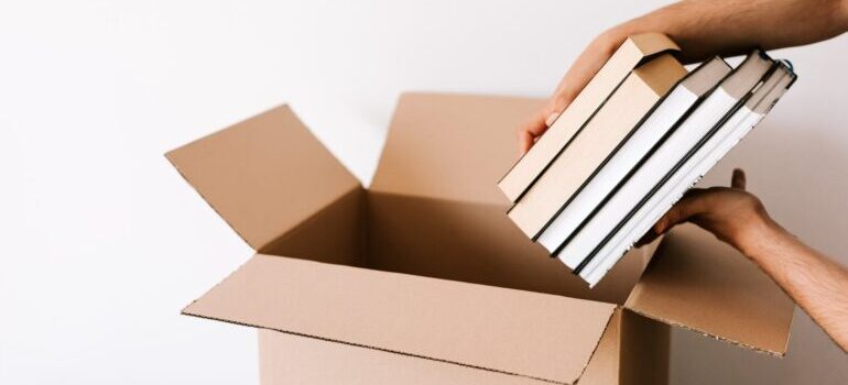 A person placing books into the box