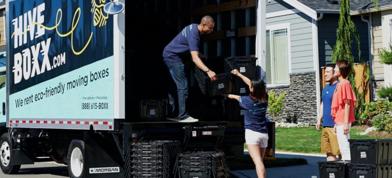 a moving crew unloading packing containers from the truck