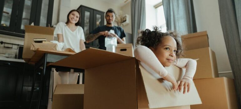 A girl sitting playing in the moving box