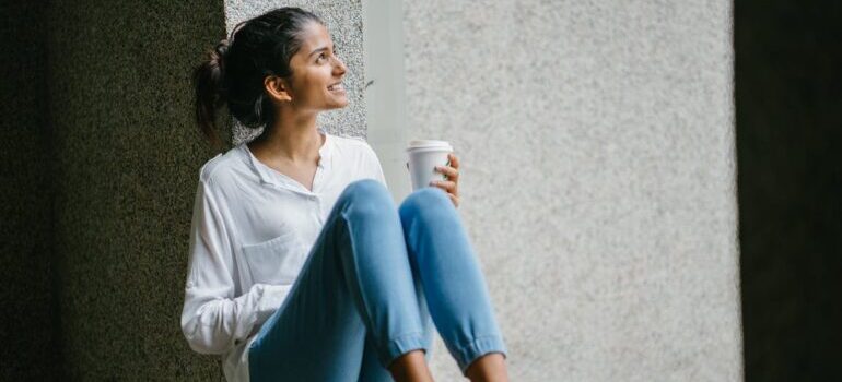A women smiling with a cup of coffee in her hand 