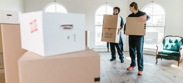 two moving company personnel carrying boxes in a home as a way for you to choose moving services you need the most when moving in Washington