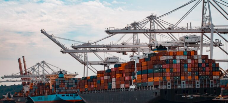 two large ships at the dock being loaded with containers