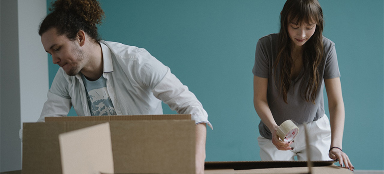 Two people packing their possessions.