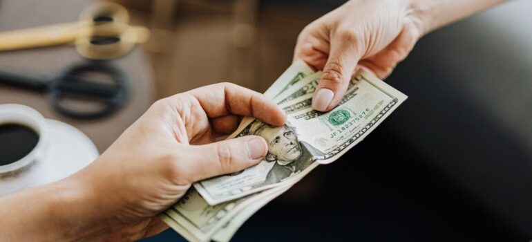 two people exchanging money in a room