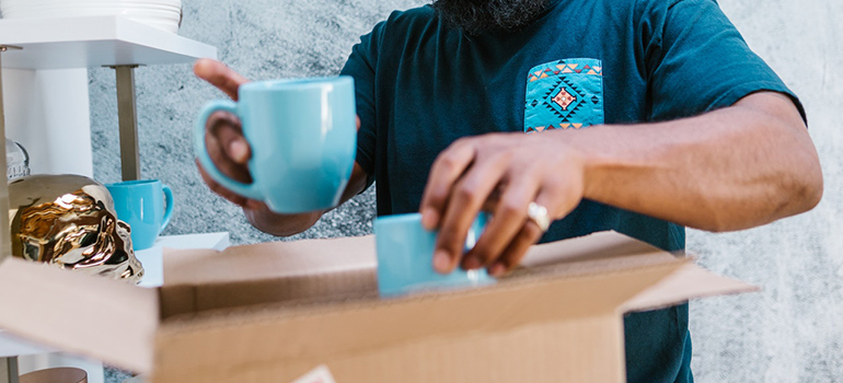 A man packing cups into a box.