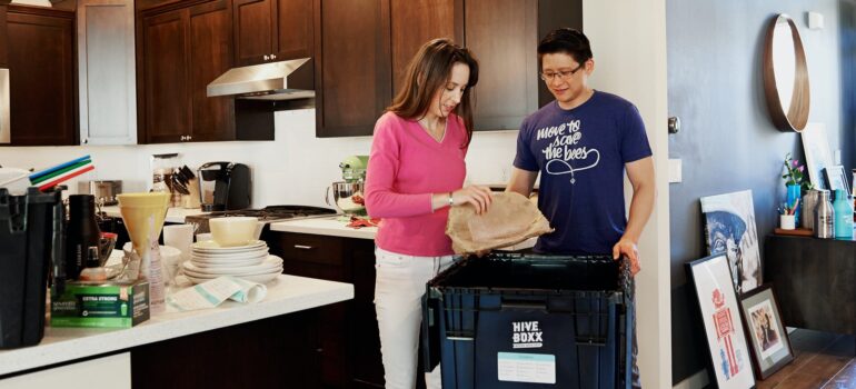 a couple placing a packed item inside a plastic bin