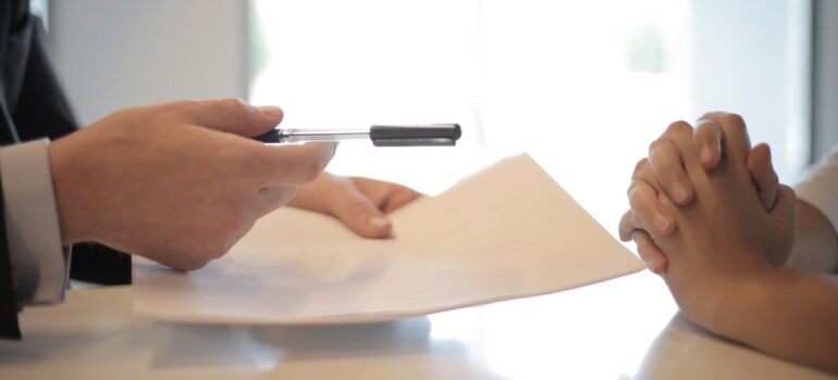 Person signing an agreement for affordable storage facilities in Alexandria