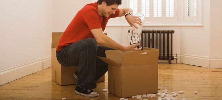 man packing electronic devices with a lot of Styrofoam peanuts for protection