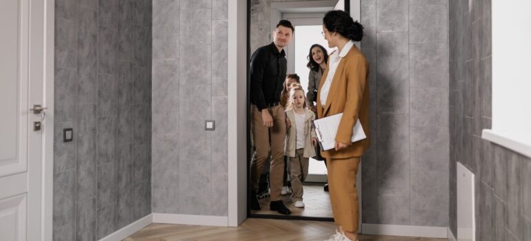 a family of four entering their newly bought home
