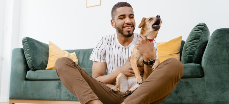 A man holding a dog in front of a couch