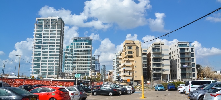 Parking lot with cars in front of the apartment buildings.