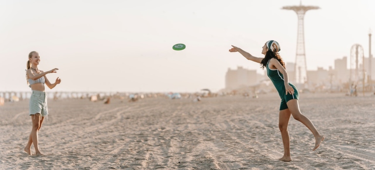 Two girls playing frisbee on the beach