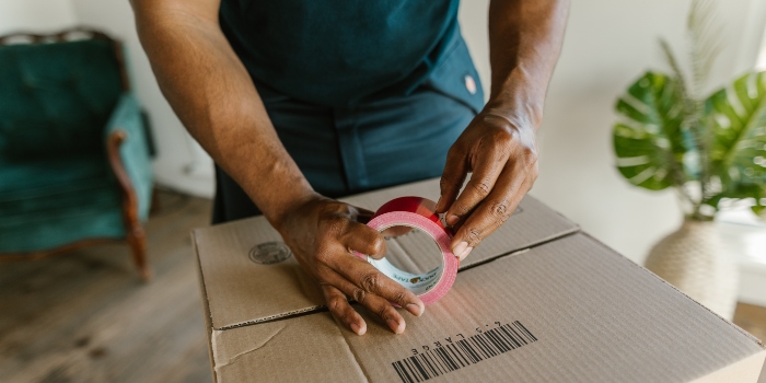 Person packing a box when moving from Alexandria to Ashburn on a budget.