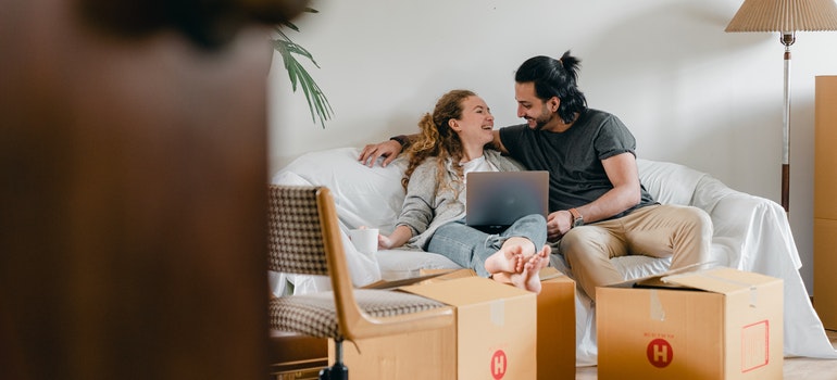 A happy couple sitting on a sofa and reading tips for international travelling