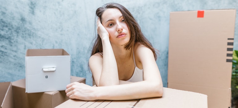 A woman with her hand on the moving box