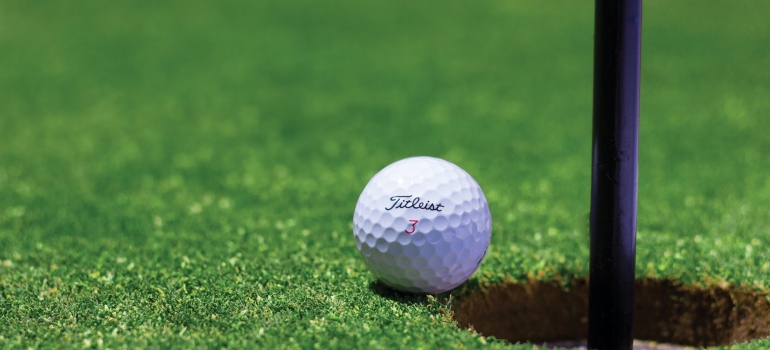 A golf ball next to a flag