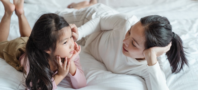 A mother and daughter talking on the bed