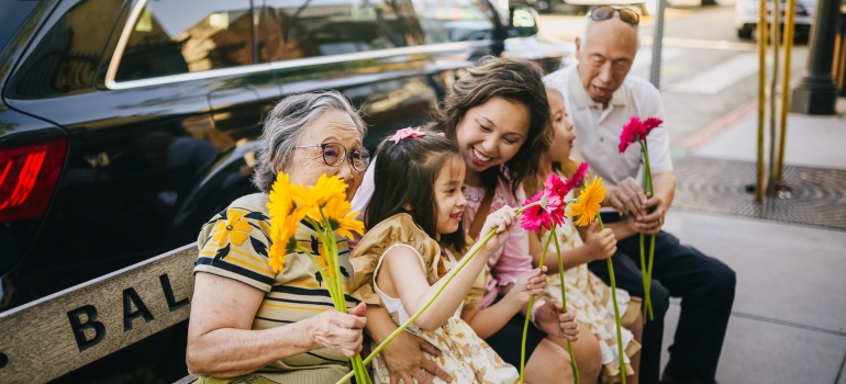 An asian family with grandparents holding flowers