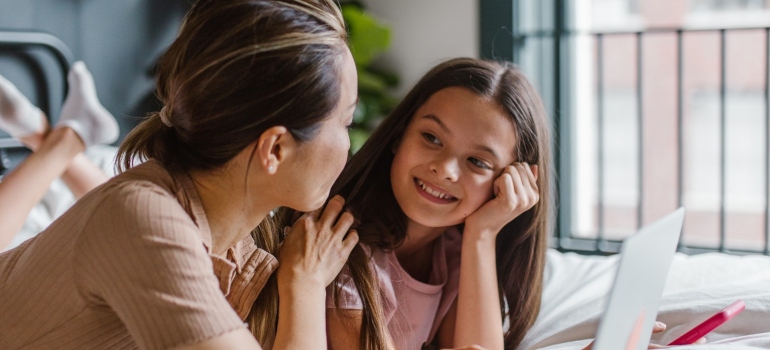 A mother talking to her daughter on the bed