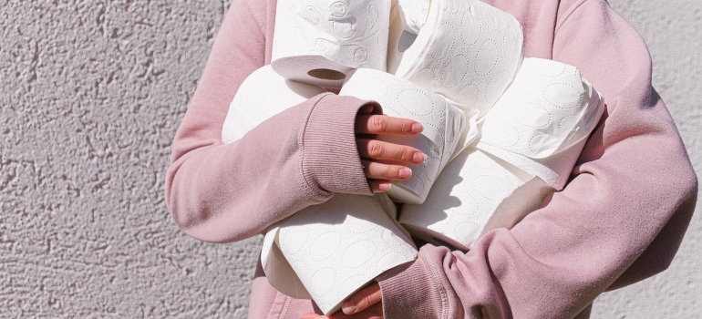 Person carrying toilet paper, one of the items to keep at hand on the moving day