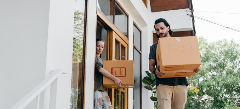 Couple carrying boxes after packing up your kitchen for relocation