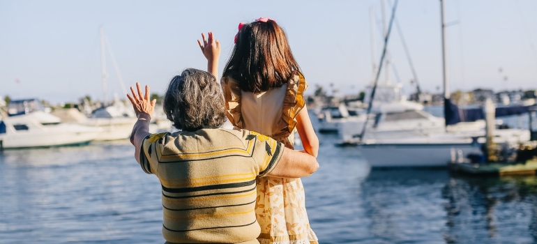 A girl and her grandma waving to the ocean
