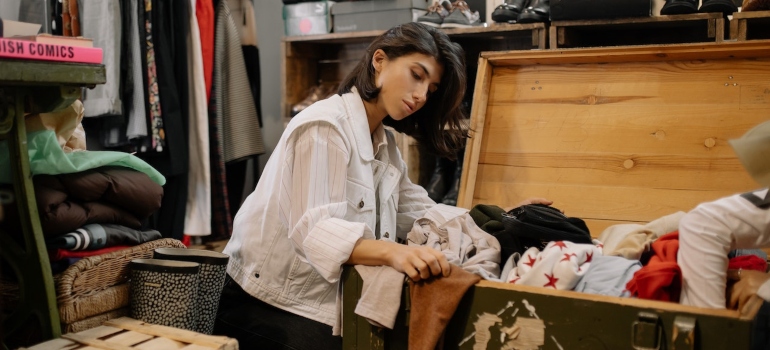 A woman sorts objects in a suitcase