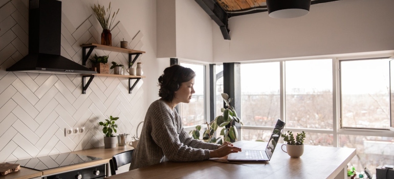 Woman reading an ultimate unpacking guide on her laptop 