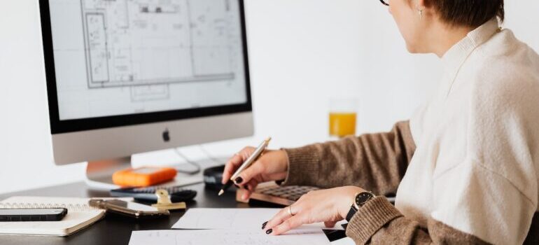 Woman in front of the computer making a plan in advance to make relocating your office quick and efficient