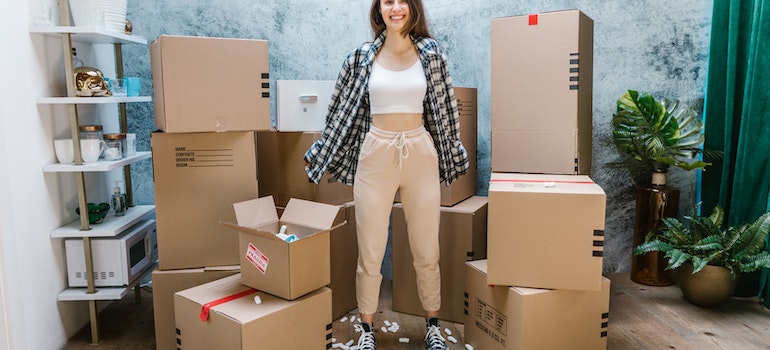 A woman smiling in front of moving boxes