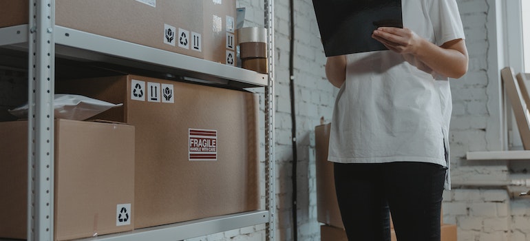 A woman in a storage unit making a list