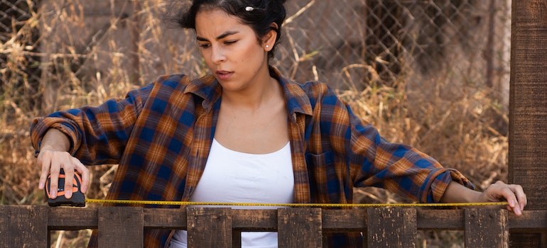 A female carpenter taking measurements