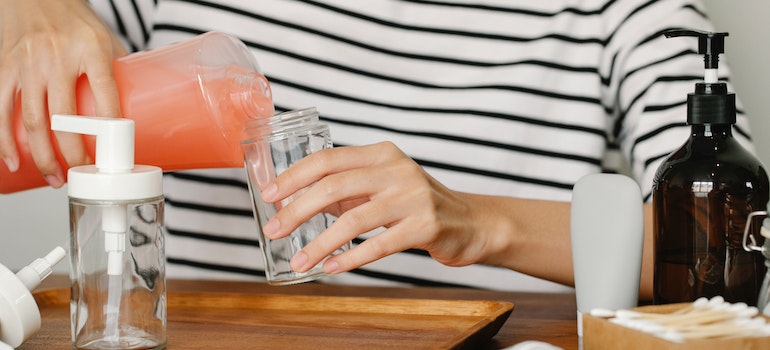 Anonymous person pouring soap from dispenser