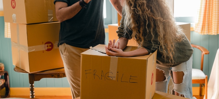 Picture of a couple who are trying to pack large house decor