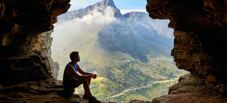 Photo of Man Sitting in a Cave.